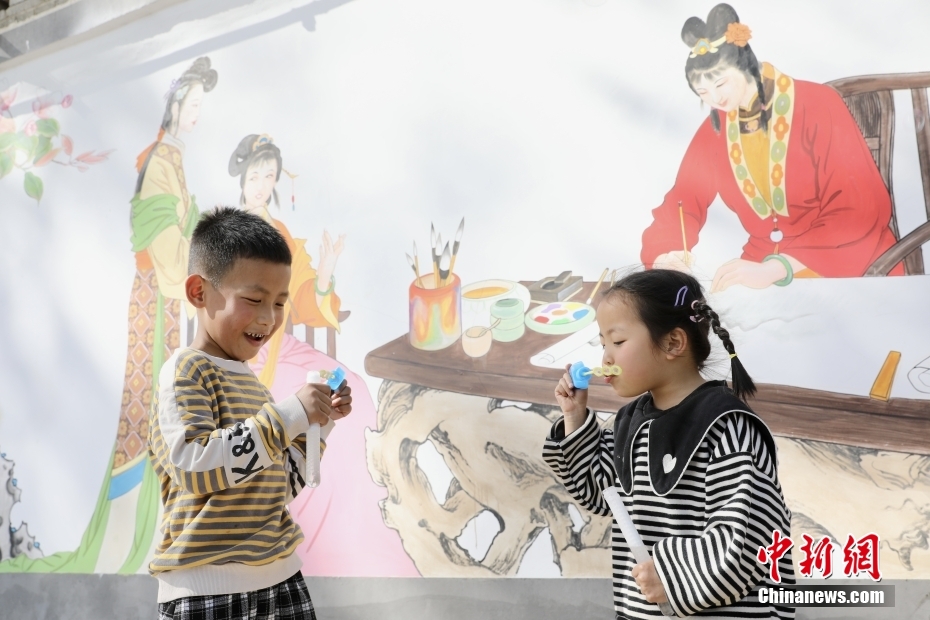 图为2022年4月7日，河渠镇褚家庄村一处工笔画墙绘下，孩子们正在玩耍。 <a target=