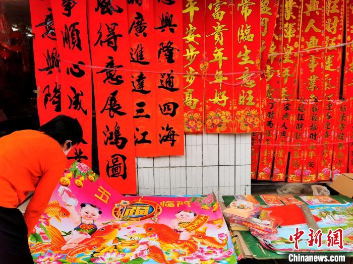 1月14日恰逢台山市四九墟“墟日”，当地的街坊在选购年画和对联 李晓春 摄