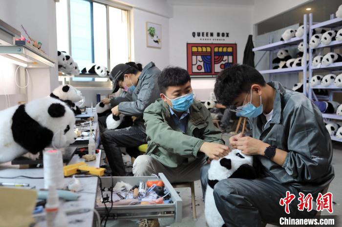 经过一番填充、剪毛和造型，一只只仿真大熊猫玩偶诞生。　王磊 摄